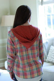 Back view of model wearing hooded flannel shirt.